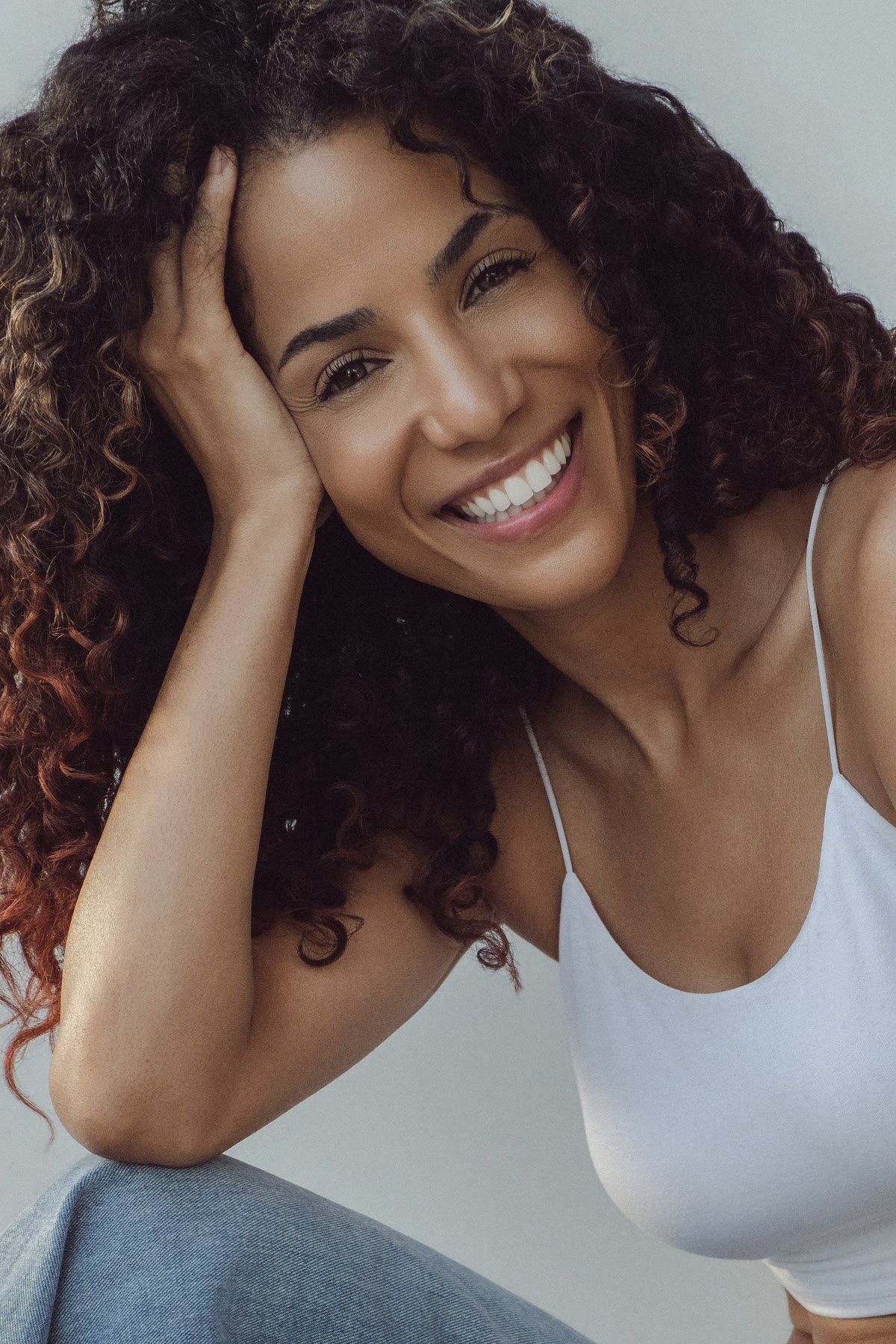 Smiling headshot of Christal resting her head on her hand