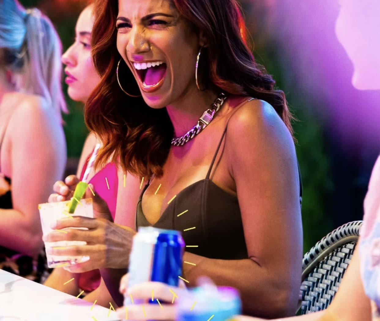 Christal laughing at the bar with a cocktail